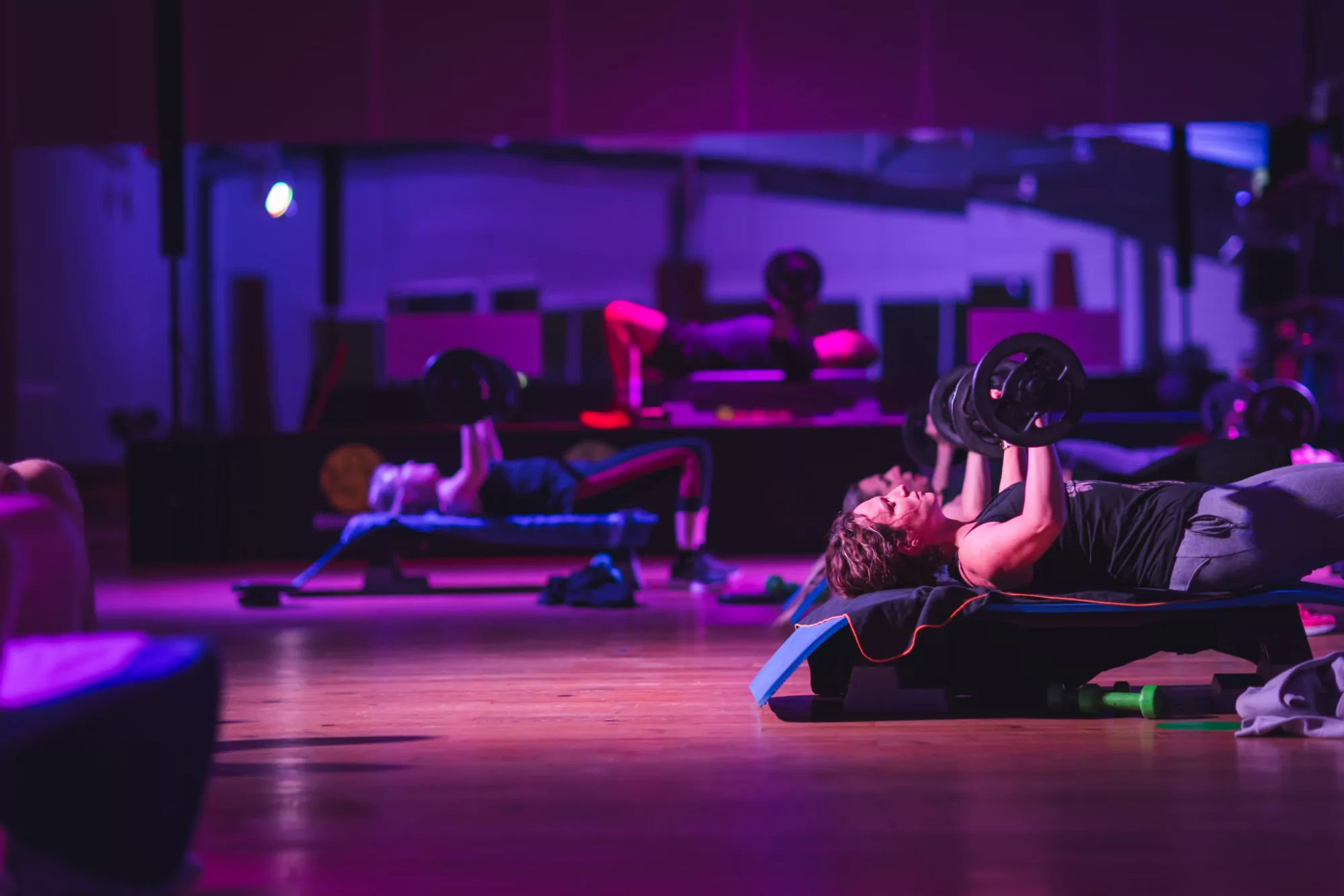 Adhérente en développé couché avec haltères pendant un cours de BODYPUMP au club SPORIUM FIT